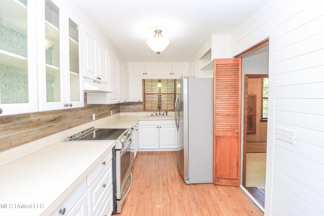 206 Oak Park Dr, Pearl, MS 39208 - kitchen with freestanding refrigerator, stainless steel electric range, under cabinet range hood, light wood-style flooring, and white cabinets