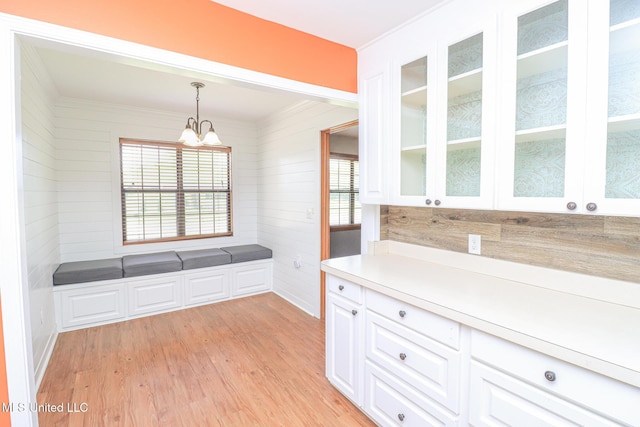 206 Oak Park Dr, Pearl, MS 39208 - unfurnished dining area featuring light wood finished floors, a chandelier, wooden walls, and crown molding