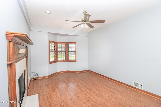 206 Oak Park Dr, Pearl, MS 39208 - unfurnished living room with a fireplace with flush hearth, light wood-style floors, a ceiling fan, and recessed lighting