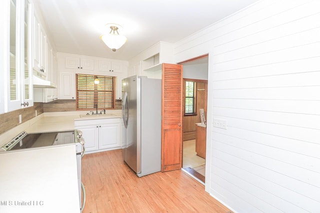 206 Oak Park Dr, Pearl, MS 39208 - kitchen with freestanding refrigerator, stove, white cabinets, light countertops, and light wood-type flooring