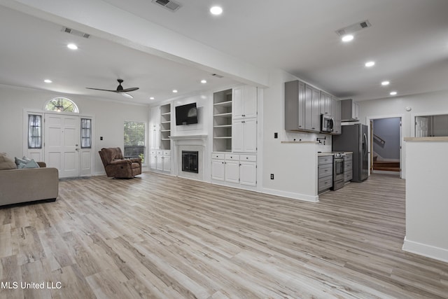 8839 Moanalua Way, Diamondhead, MS 39525 - living room with ceiling fan, a glass covered fireplace, recessed lighting, and light wood-type flooring