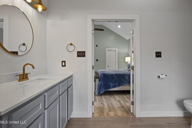 8839 Moanalua Way, Diamondhead, MS 39525 - ensuite bathroom with vaulted ceiling, vanity, and wood finished floors