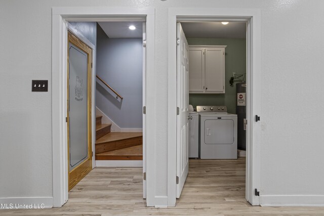 8839 Moanalua Way, Diamondhead, MS 39525 - washroom with washer and dryer, light wood-type flooring, cabinet space, and water heater