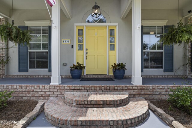 8839 Moanalua Way, Diamondhead, MS 39525 - view of exterior entry featuring covered porch and stucco siding