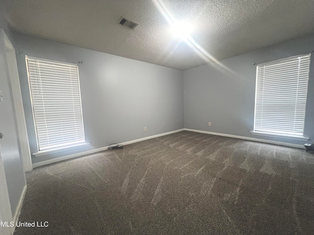 carpeted spare room featuring a textured ceiling