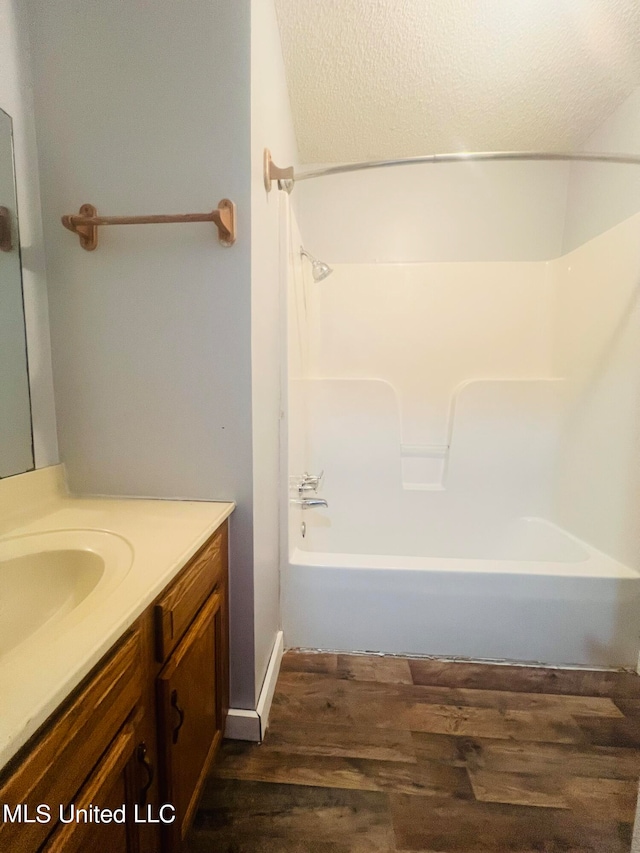 bathroom with hardwood / wood-style flooring, vanity, and bathing tub / shower combination