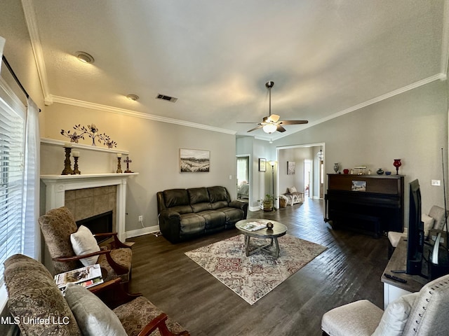 living room with dark wood-type flooring, crown molding, vaulted ceiling, ceiling fan, and a fireplace