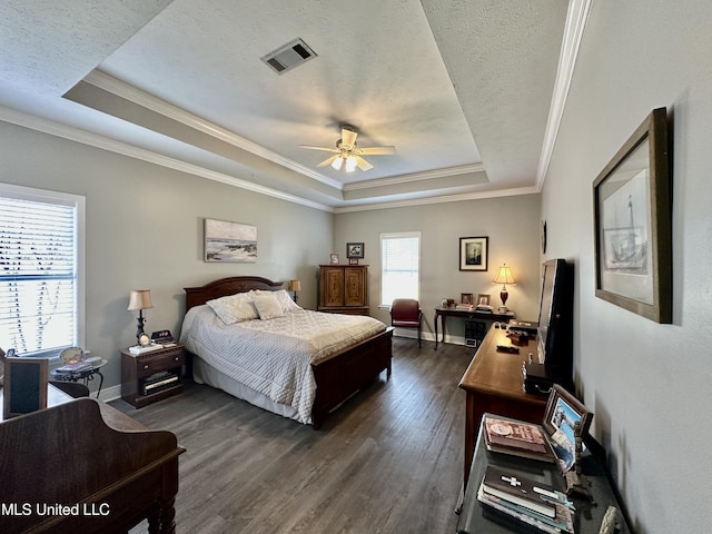 bedroom featuring a textured ceiling, ornamental molding, dark hardwood / wood-style flooring, a raised ceiling, and ceiling fan