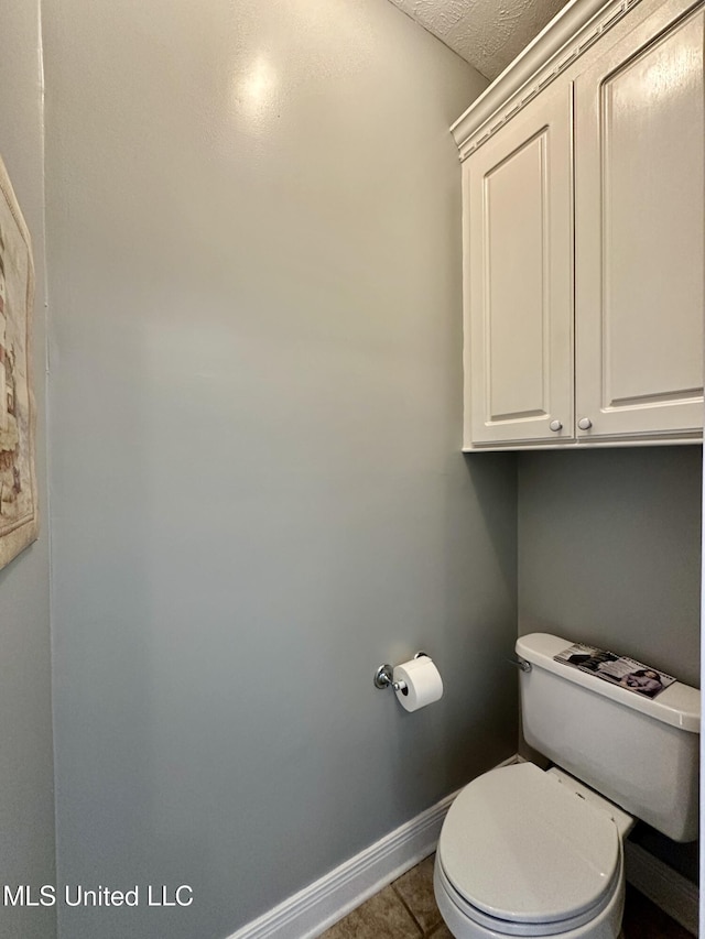 bathroom with toilet, tile patterned flooring, and a textured ceiling