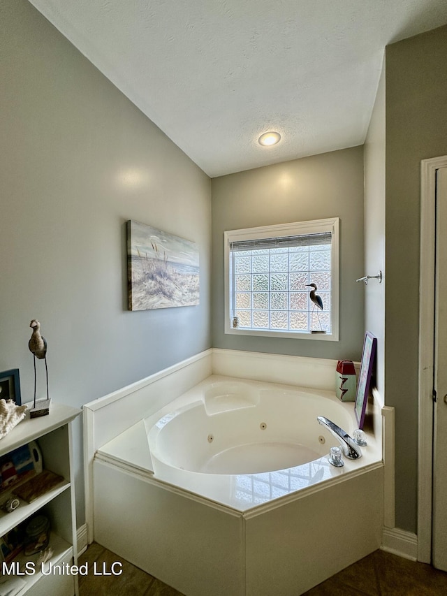 bathroom featuring a bath and a textured ceiling