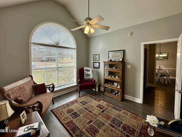 living area with dark wood-type flooring, ceiling fan, and vaulted ceiling