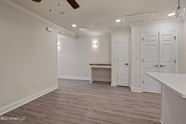 interior space with crown molding, baseboards, and wood finished floors