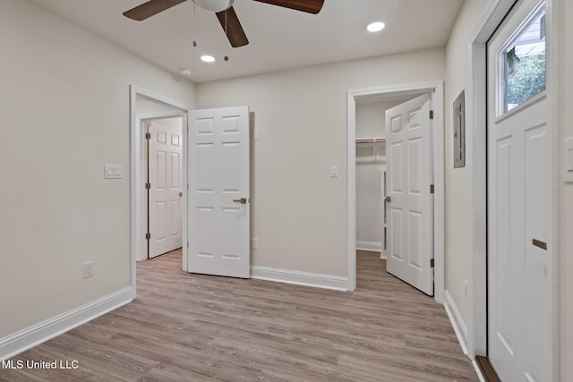 unfurnished bedroom with a spacious closet, recessed lighting, light wood-style flooring, and baseboards