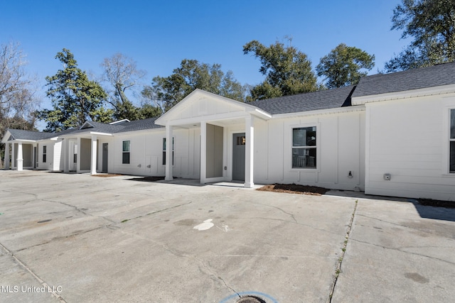 modern farmhouse style home with board and batten siding and roof with shingles