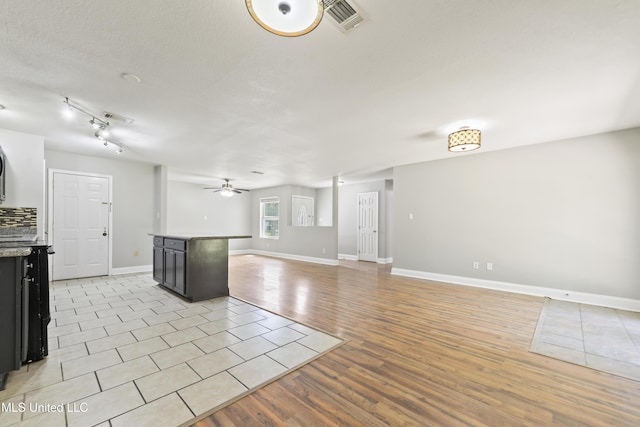2607 Calle De Feliz St, Gautier, MS 39553 - kitchen featuring a kitchen island, open floor plan, a ceiling fan, light countertops, and dark cabinets