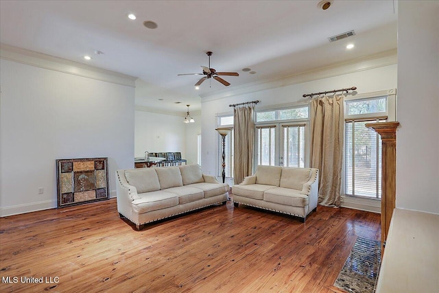 living room with ceiling fan, ornamental molding, and wood-type flooring