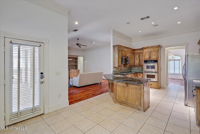 kitchen featuring sink, light tile patterned floors, ornamental molding, kitchen peninsula, and stainless steel appliances