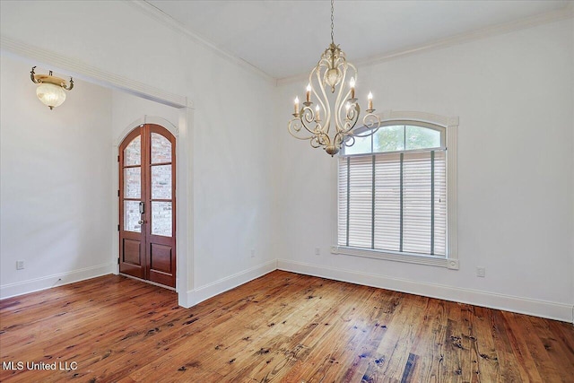 entrance foyer featuring crown molding, wood-type flooring, and french doors