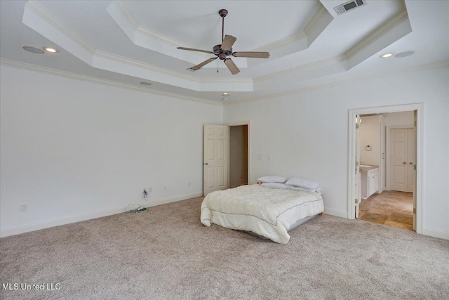 carpeted bedroom featuring crown molding and a tray ceiling