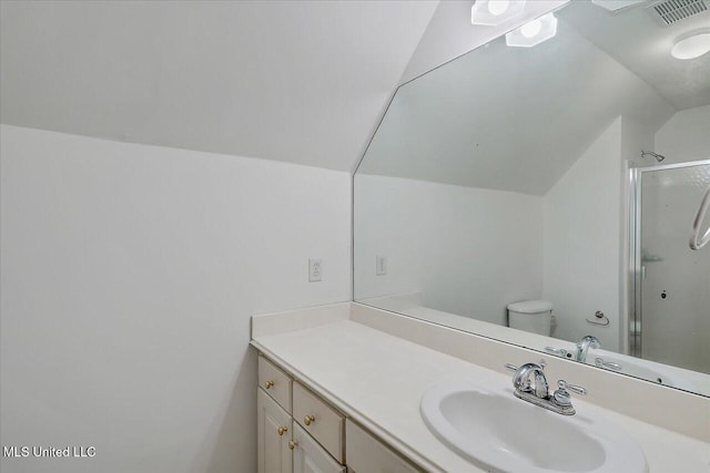 bathroom with lofted ceiling, vanity, a shower with door, and toilet