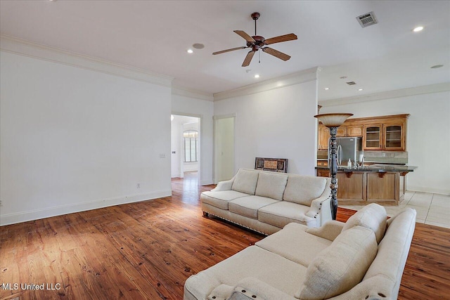 living room featuring dark wood-type flooring, ceiling fan, crown molding, and sink