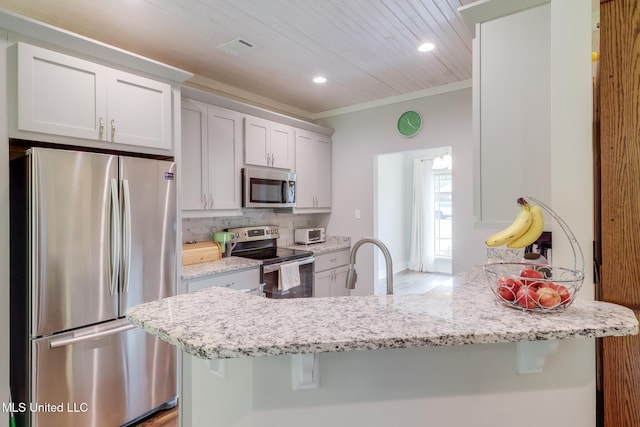 508 Dynsmore Pl, Long Beach, MS 39560 - kitchen with stainless steel appliances, a peninsula, light stone countertops, decorative backsplash, and crown molding