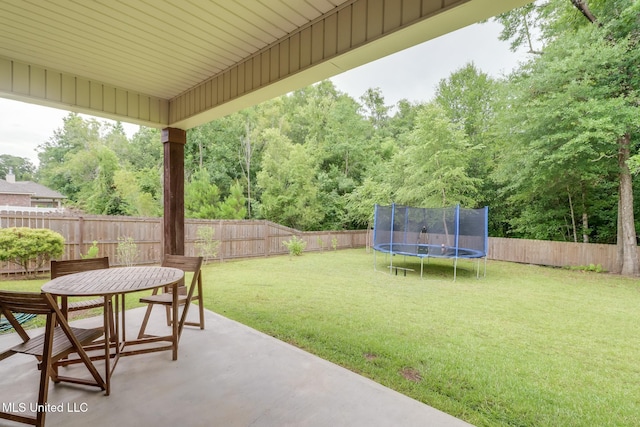 508 Dynsmore Pl, Long Beach, MS 39560 - fenced backyard featuring a patio, a trampoline, outdoor dining area, and a forest view