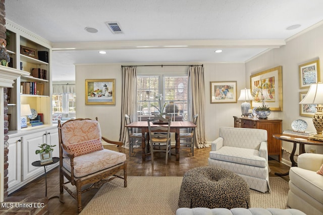 living area with ornamental molding, beamed ceiling, visible vents, and baseboards