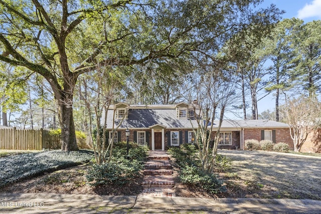 view of front of house with fence and brick siding