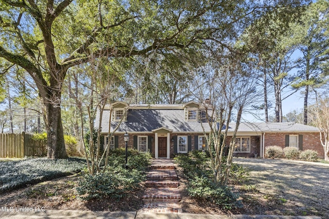 view of front of property featuring brick siding and fence