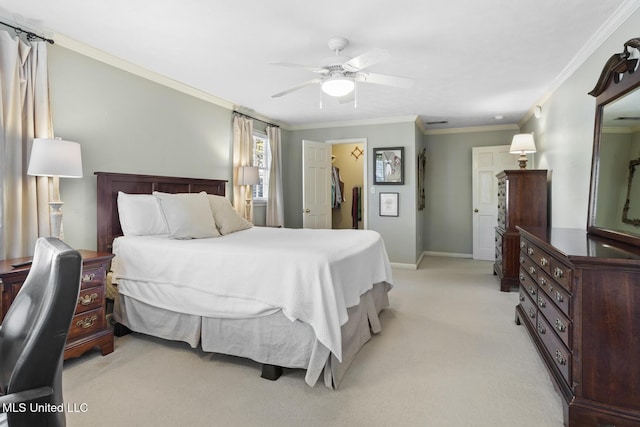 bedroom featuring a walk in closet, ornamental molding, a ceiling fan, light carpet, and baseboards