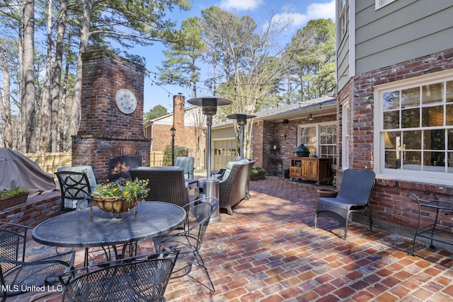 view of patio / terrace featuring an outdoor living space with a fireplace and fence