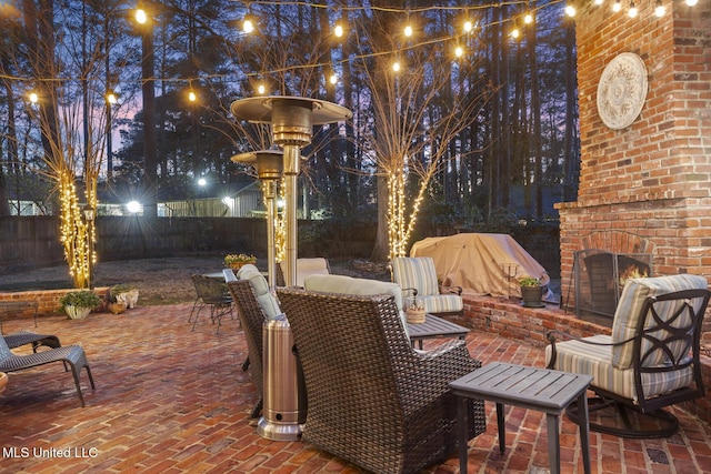 view of patio with an outdoor brick fireplace, a fenced backyard, and outdoor dining space