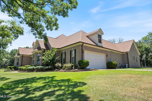 view of front of house featuring cooling unit, a front yard, and a garage