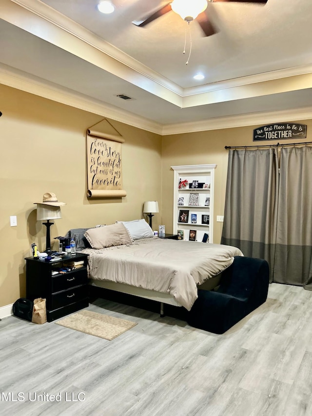 309 College St, Carthage, MS 39051 - bedroom with wood finished floors, a tray ceiling, visible vents, ornamental molding, and recessed lighting
