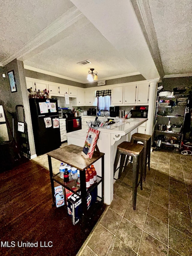 309 College St, Carthage, MS 39051 - kitchen with a textured ceiling, visible vents, and black appliances