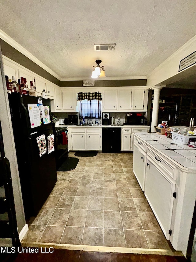 309 College St, Carthage, MS 39051 - kitchen with ornamental molding, a textured ceiling, tile countertops, black appliances, and visible vents