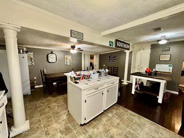309 College St, Carthage, MS 39051 - kitchen with tile countertops, ornamental molding, ceiling fan, decorative columns, and white cabinetry