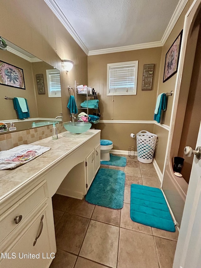 309 College St, Carthage, MS 39051 - bathroom featuring a textured ceiling, toilet, ornamental molding, tile patterned floors, and vanity