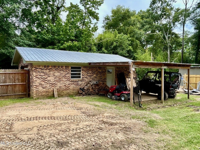 309 College St, Carthage, MS 39051 - view of outdoor structure featuring a carport and dirt driveway