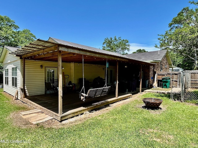 309 College St, Carthage, MS 39051 - rear view of house with a yard, a wooden deck, a fire pit, and fence