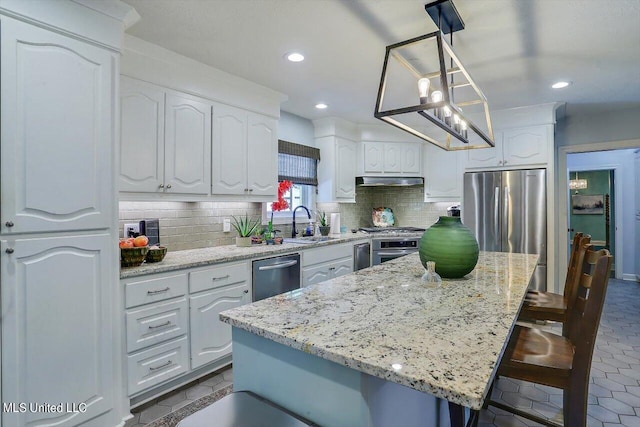 kitchen with a kitchen breakfast bar, a kitchen island, white cabinets, and hanging light fixtures