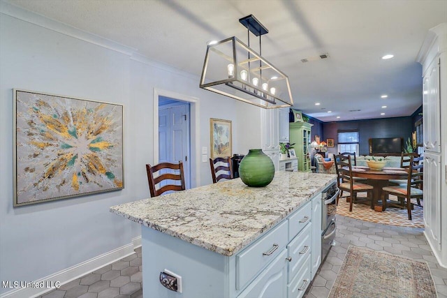 kitchen with a center island, light stone counters, hanging light fixtures, white cabinetry, and crown molding