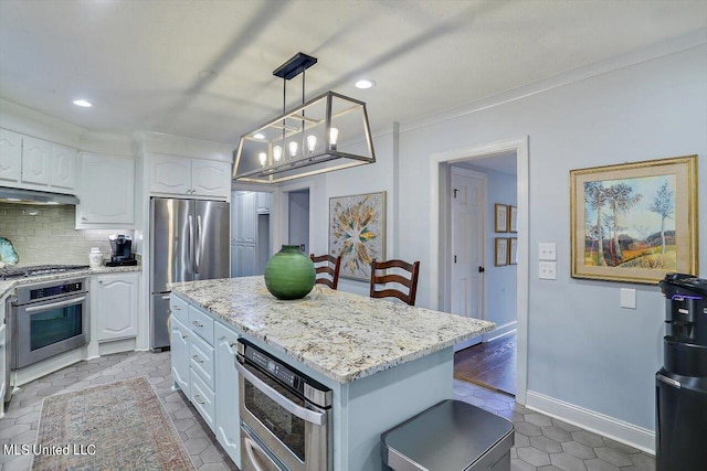 kitchen featuring a kitchen island, hanging light fixtures, light stone countertops, white cabinets, and appliances with stainless steel finishes