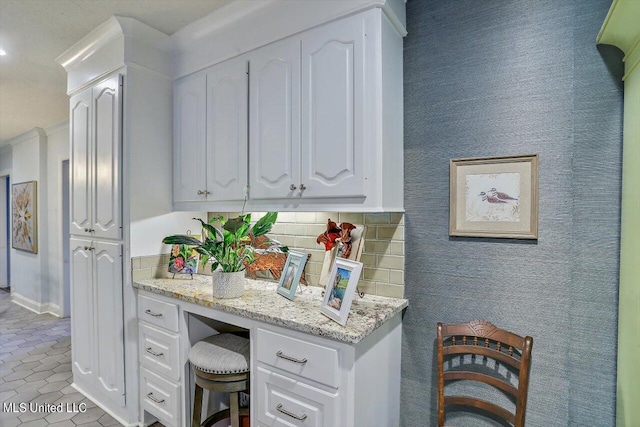 kitchen with white cabinetry, light stone counters, light tile patterned floors, and tasteful backsplash