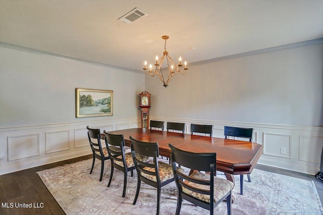 dining space featuring ornamental molding, dark hardwood / wood-style floors, and an inviting chandelier