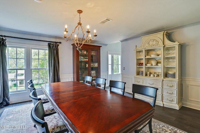 dining space featuring dark wood-type flooring, a notable chandelier, and plenty of natural light