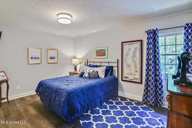 bedroom featuring a textured ceiling and dark hardwood / wood-style flooring