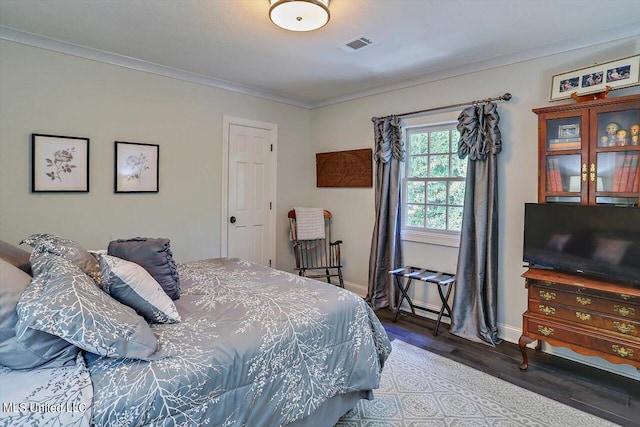 bedroom featuring hardwood / wood-style floors and crown molding