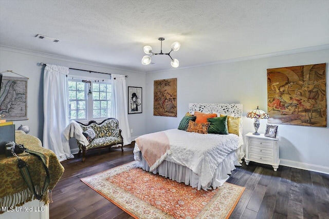 bedroom featuring ornamental molding, a notable chandelier, a textured ceiling, and dark hardwood / wood-style flooring